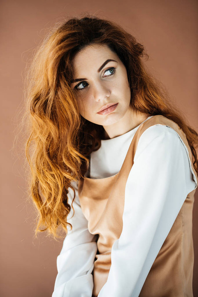 Beautiful young girl looking away isolated on brown background - Фото, зображення