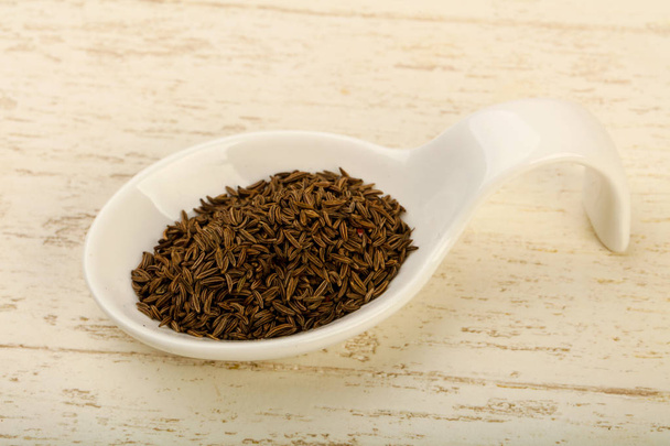 Caraway pile in the bowl over wooden background - Foto, imagen