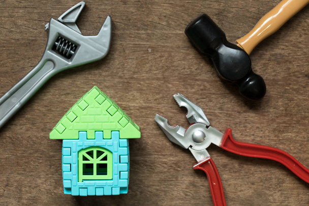 Объект домашней модели с инструментом игрушечного оборудования на деревянном фоне (Концепция ремонта или ремонта дома
) - Фото, изображение