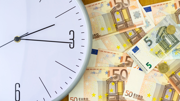 Klok en bankbiljetten van de Euro. Begrip tijd is geld. Bekijk van bovenaf. Business, finance. - Foto, afbeelding