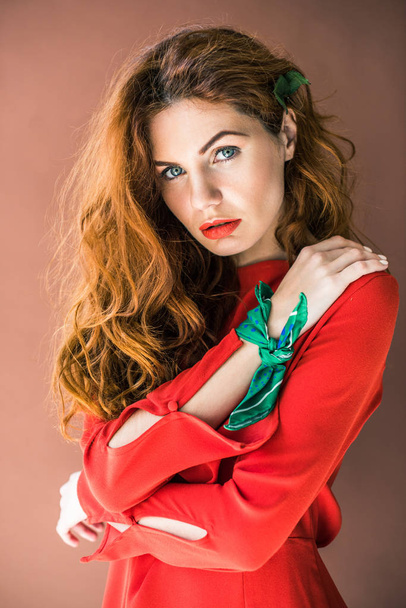 Hermosa joven en vestido rojo aislado sobre fondo marrón
 - Foto, Imagen