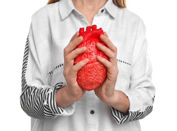 Woman holding model of heart on white background. Heart attack concept - Foto, Bild