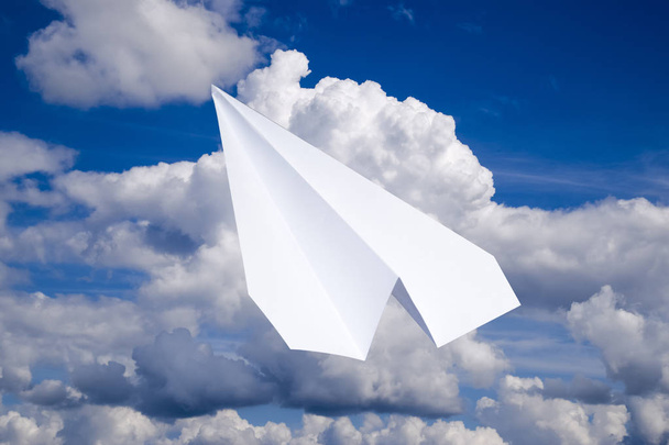 Fehér papír repülőgép a kék égen a felhők. Az üzenet szimbóluma a Messenger - Fotó, kép