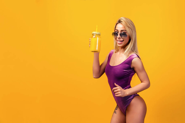 Alluring tattooed model with refreshing drink - Foto, imagen