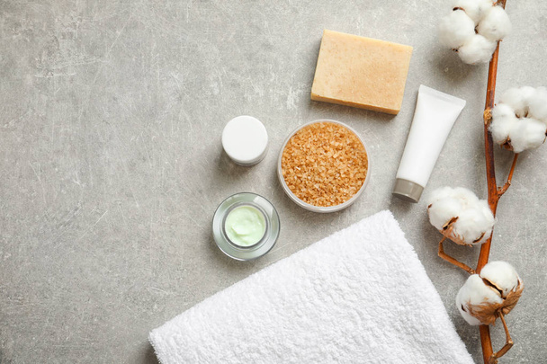 Flat lay composition with spa cosmetics and towel on grey background - Fotografie, Obrázek