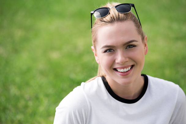 portrait of beautiful blonde girl with sunglasses on head smiling at camera outdoors - Φωτογραφία, εικόνα