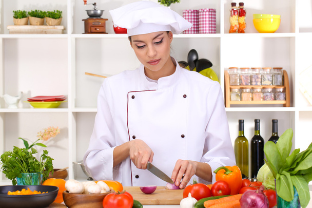Young woman chef cooking in kitchen - Foto, Bild