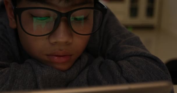 Close up van leuke Aziatische jongen dragen van bril en het gebruik van tablet pc, jonge tiener jongen spelen van spelletjes op digitale tablet . - Video