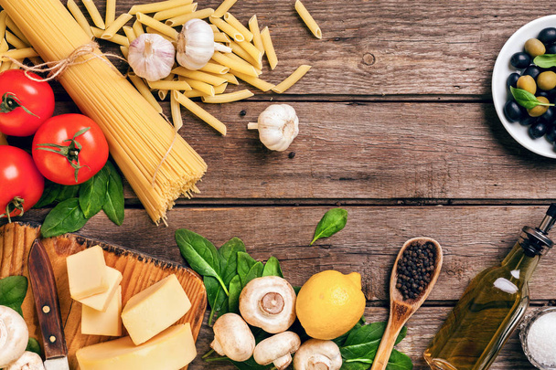 Ingredientes para espaguetis con albahaca, tomates, queso sobre fondo de madera, vista superior, lugar para texto
 - Foto, imagen