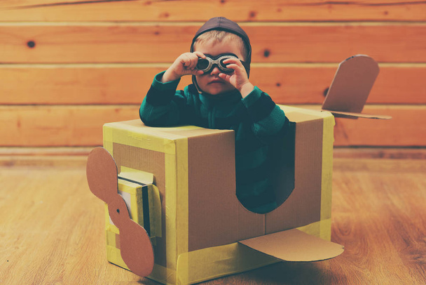 Kid, pilot school, innovation. Pilot travel, airdrome, imagination. Little boy child play in cardboard plane, childhood. Air mail delivery, aircraft construction. Dream, career, adventure, education. - Photo, image