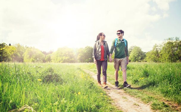 happy couple with backpacks hiking outdoors - Fotoğraf, Görsel