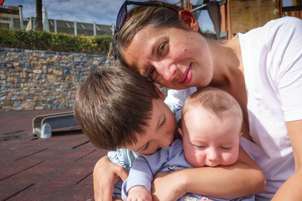 Portret van een moeder met twee zoons op Speeltuin, Griekenland - Foto, afbeelding