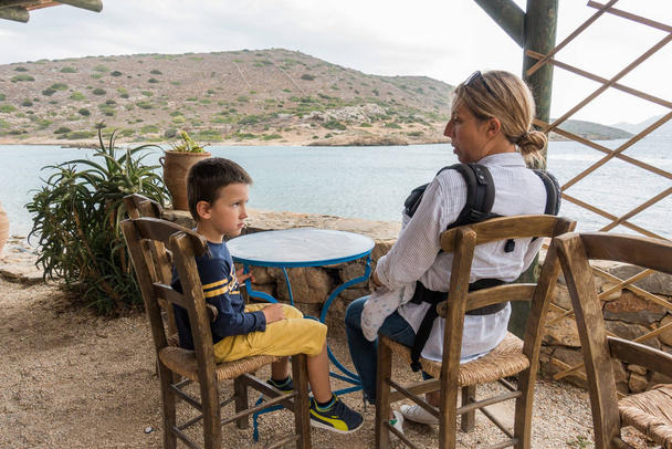 Mère avec son fils assis au restaurant extérieur face à la mer
 - Photo, image