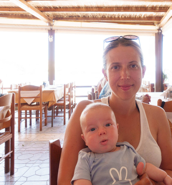 Madre con su pequeño bebé en el restaurante, Heraklion, Grecia
 - Foto, Imagen