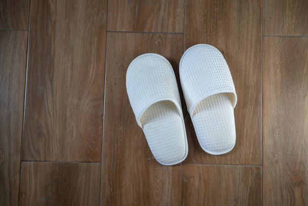 A pair of white disposable slippers with soft foam texture for i - 写真・画像