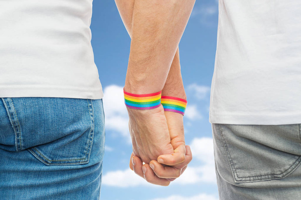 male couple with gay pride rainbow wristbands - Foto, imagen