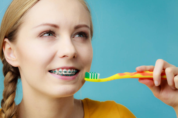 Woman with teeth braces using brush - 写真・画像