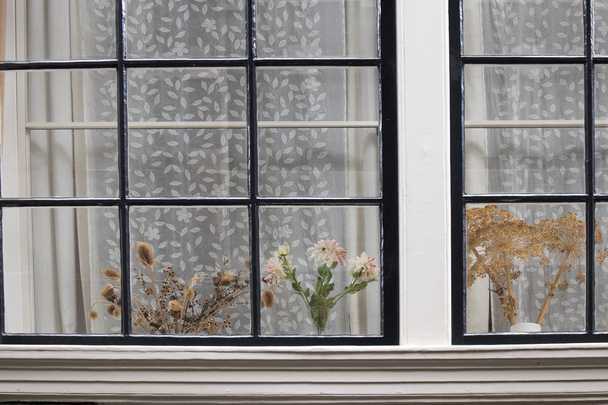 the Traditional Dutch window with tulle and dry bouquets on the windowsill - Foto, immagini