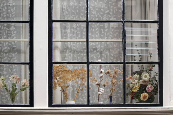 the Traditional Dutch window with tulle and dry bouquets on the windowsill - Фото, изображение