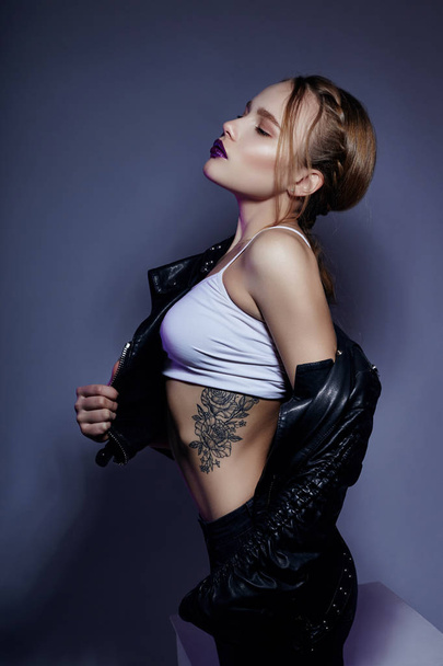 Sexy blonde Girl with tattoo in leather jacket and jeans, portra - Фото, изображение