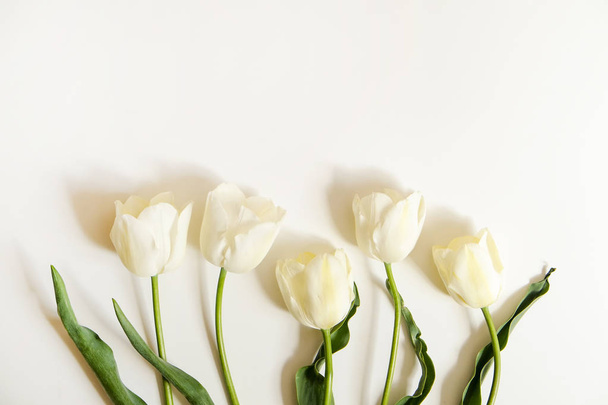 Beautiful spring holidays flowers arrangment. Bunch of white tulips in festive composition, copy space for text, white background. - Foto, Imagem