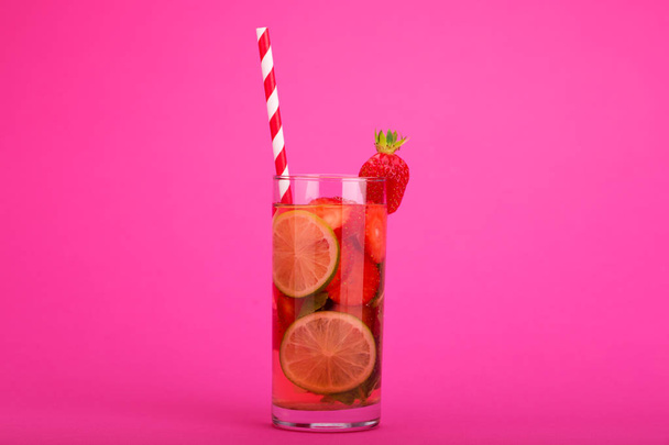frische Limonade mit Erdbeeren, Limette und Minze in einem hohen Glas auf weißem und rosa Hintergrund - Foto, Bild