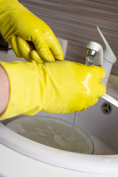 Washing dishes in yellow gloves - Photo, Image