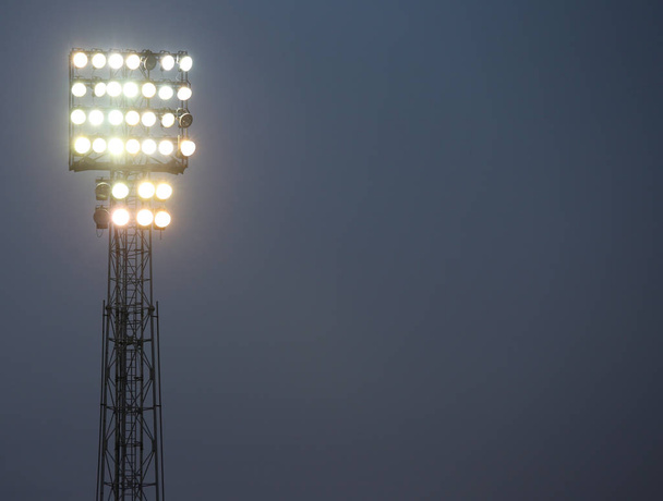 прожекторы футбольного стадиона освещены, чтобы осветить поле
 - Фото, изображение