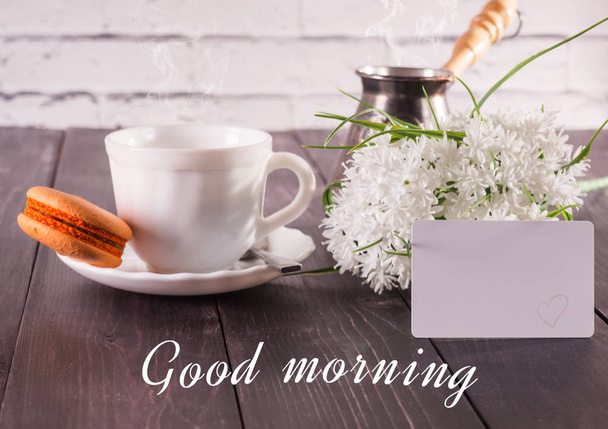 Coffee, macarons on a saucer and a bouquet of flowers with a card the inscription is a good morning - Zdjęcie, obraz