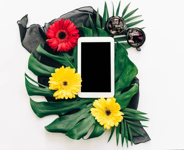 Flat lay digital tablet over tropical leaf monstera. Top view  - Valokuva, kuva