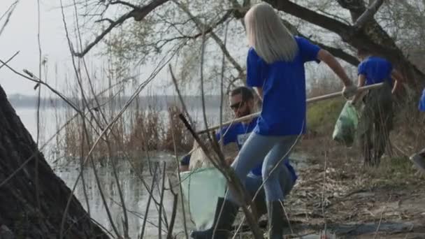 Menschen reinigen Teichufer im Wald - Filmmaterial, Video