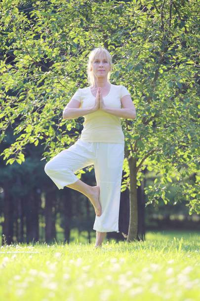 Yoga woman in park - Фото, изображение