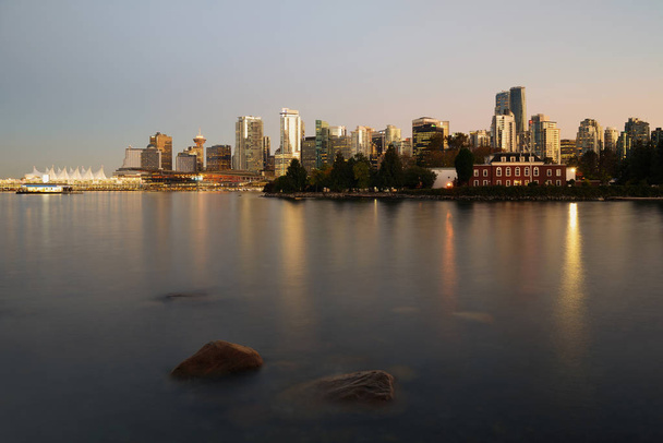 Vancouver v centru architektury a loď s odrazy vody a skály za soumraku - Fotografie, Obrázek