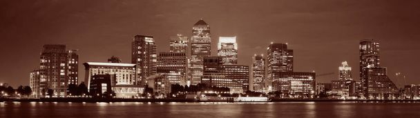 Distrito de negocios de Canary Wharf en Londres por la noche sobre el río Támesis.  - Foto, imagen