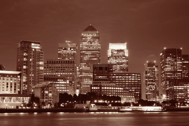 Canary Wharf business district Lontoossa yöllä yli Thames River.  - Valokuva, kuva