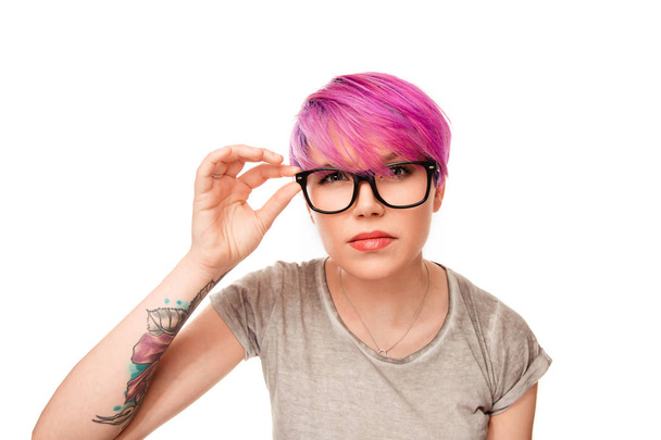 woman with magenta pink hair and green eyes frowning her eyebrows holding glasses - Foto, afbeelding