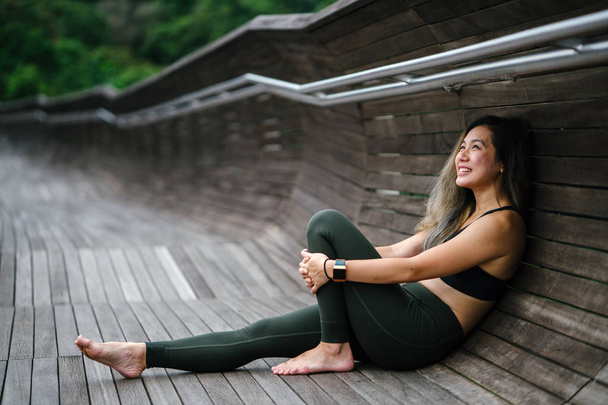 Portret atrakcyjna, młoda kobieta Azji chińskim ubrana w sportowy, active wear w parku publicznym w Singapurze w ciągu dnia na weekend. - Zdjęcie, obraz