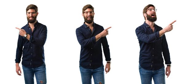 Young man with beard pointing away side with finger isolated over white background - Photo, Image