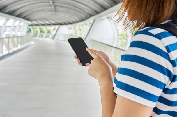 Chica turista Asiáticos de 25-35 años utilizan teléfonos inteligentes para encontrar destinos. Encontrar lugares de interés. El uso de teléfonos inteligentes hoy en día es muy importante para viajar hoy. utilizar como concepto de viaje de fondo
. - Foto, imagen