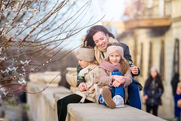 Mother and little daughters outdoor in city - 写真・画像
