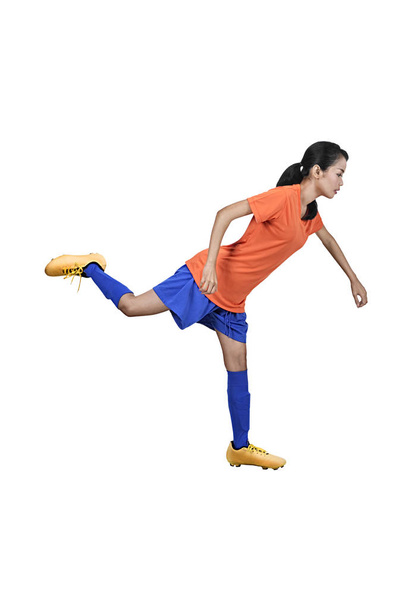 professionelle asiatische Fußballerin, die Ball über weißem Hintergrund kickt - Foto, Bild