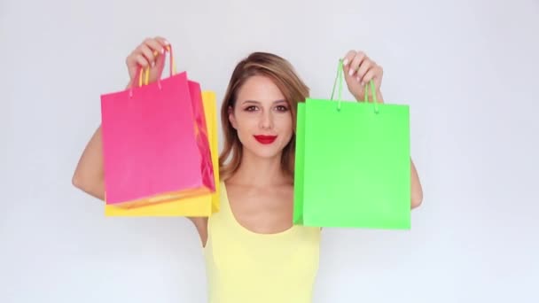 Menina ruiva jovem com sacos de compras no fundo branco
 - Filmagem, Vídeo