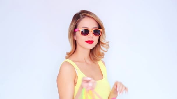 Jonge roodharige meisje in zonnebril met boodschappentassen op witte achtergrond - Video