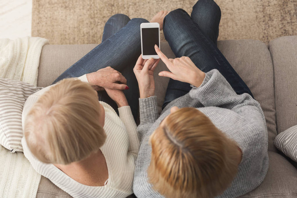 Erwachsene Frau und Tochter nutzen Smartphone-Draufsicht - Foto, Bild