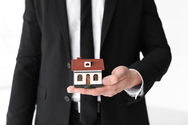 Male real estate agent with house model, closeup - Zdjęcie, obraz