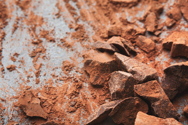 Crushed chocolate pieces and cocoa on gray background - Foto, Imagem