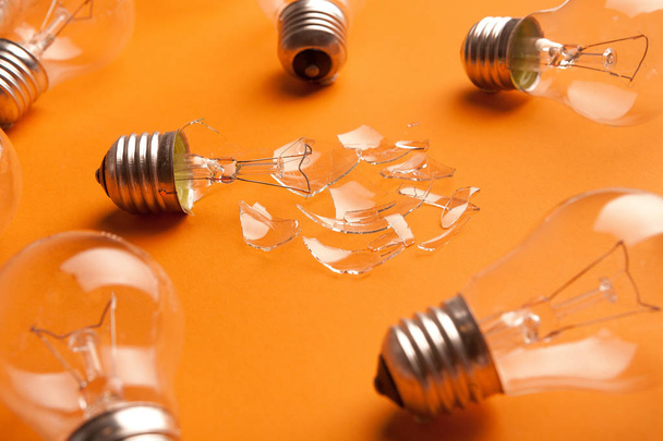 Whole and broken light bulbs on yellow background - Photo, Image