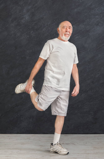 Starší muž strečink nohou doma - Fotografie, Obrázek