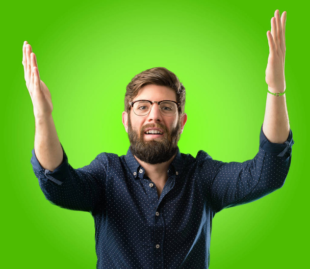 Молодой хипстер с большой бородой уверенный и счастливый с большой естественной улыбкой приветственный жест на зеленом фоне
 - Фото, изображение
