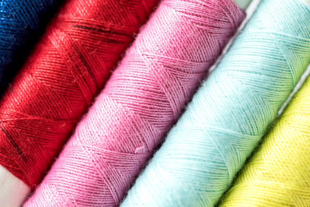 Close-up van een multi-kleur van klossen draden als achtergrond rollen - Foto, afbeelding